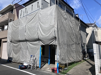 ベランダ全体を交換することになりました。足場を組み、飛散防止のカバーで覆います。